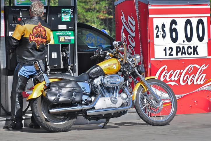 Fort Myers, USA - November 17, 2009: Harley Davidson biker in leather clothes with his bike stands at a fuel station.